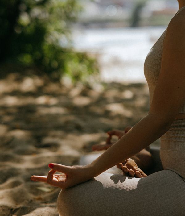 Woman in a calm yoga pose, meditating in a serene environment.